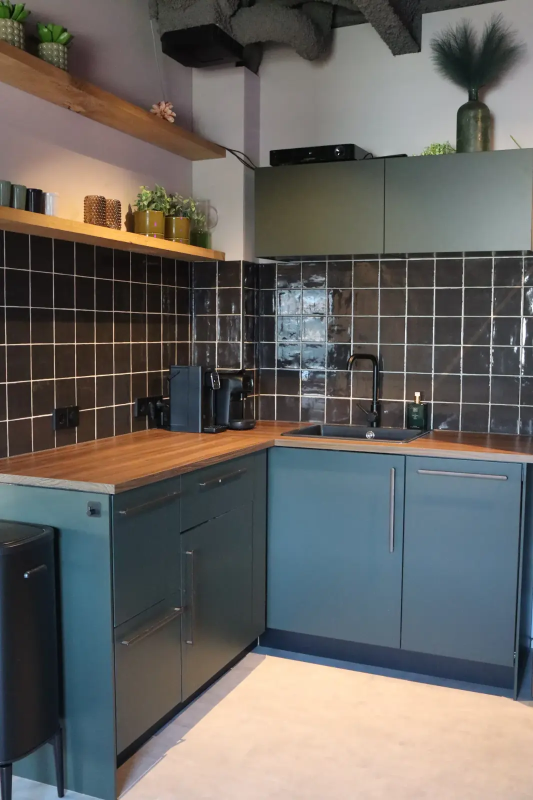 Saliegroene keuken met zwarte tegels