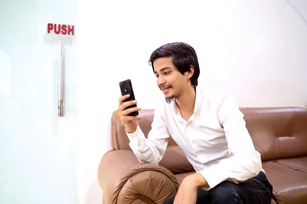 Jongen leest blij een bericht op zijn telefoon