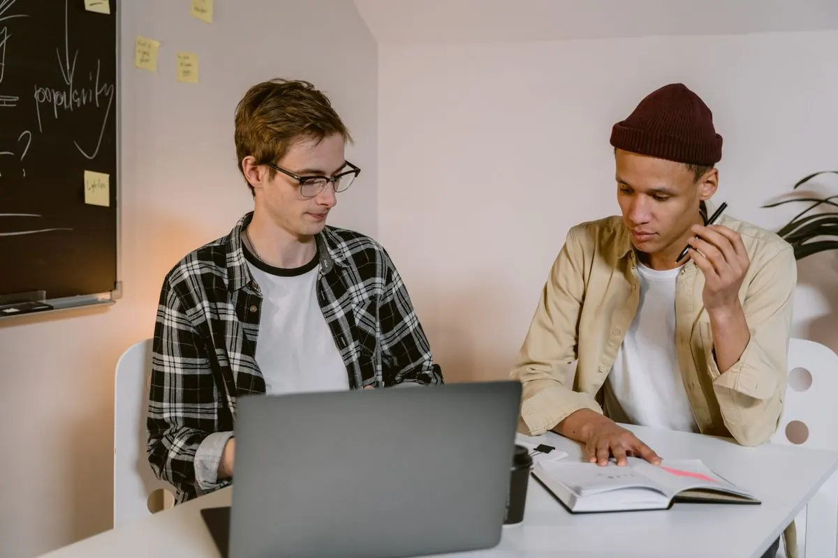 Twee jonge ondernemers werken samen achter een laptop